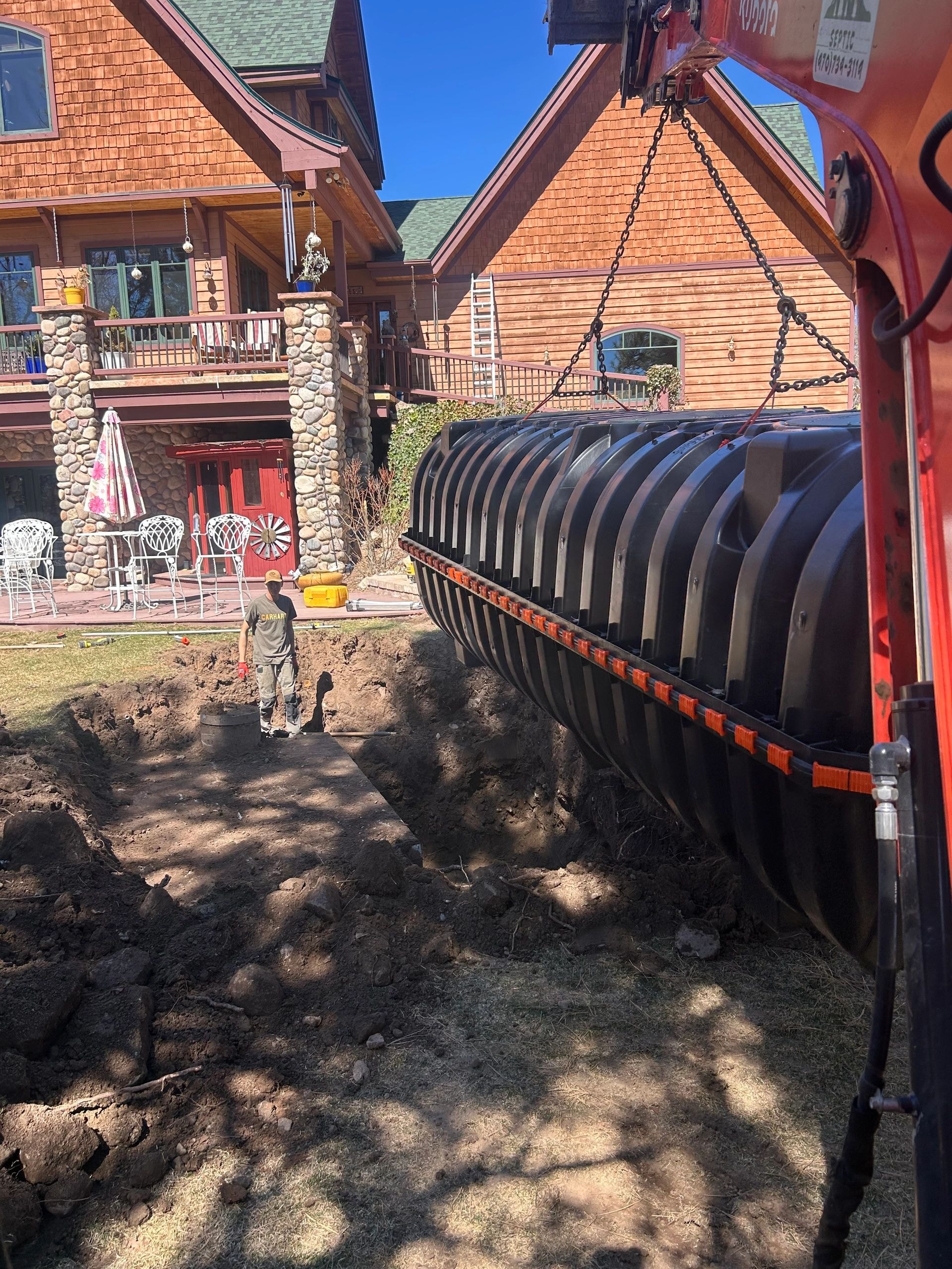 Septic tank being lowered into excavated pit
